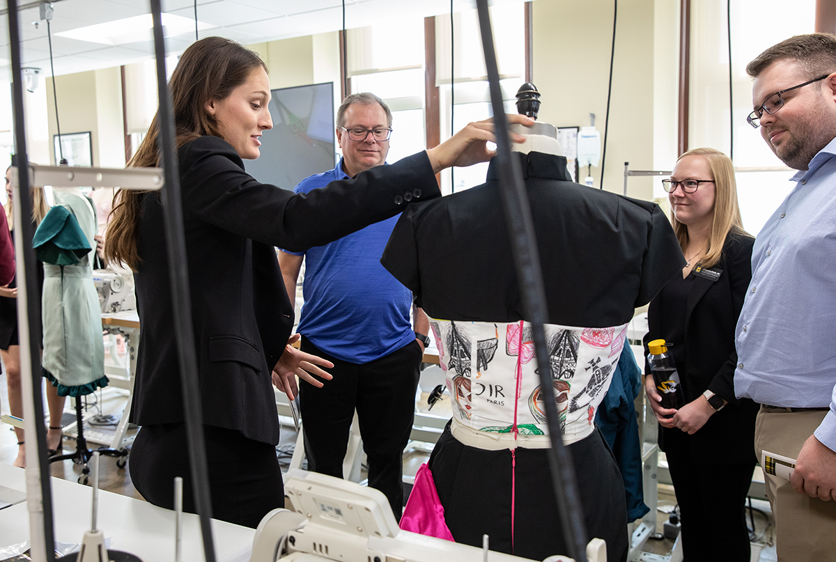 Textile and Apparel Management student displays their custom designed outfit during an open house